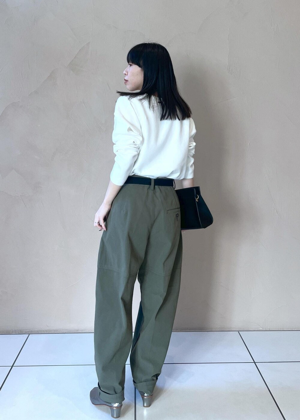 ブラック系のショルダーバッグ、ホワイト系のニット/セーター、グリーン系のその他パンツを着用したレディースの冬コーディネートの6枚目の写真