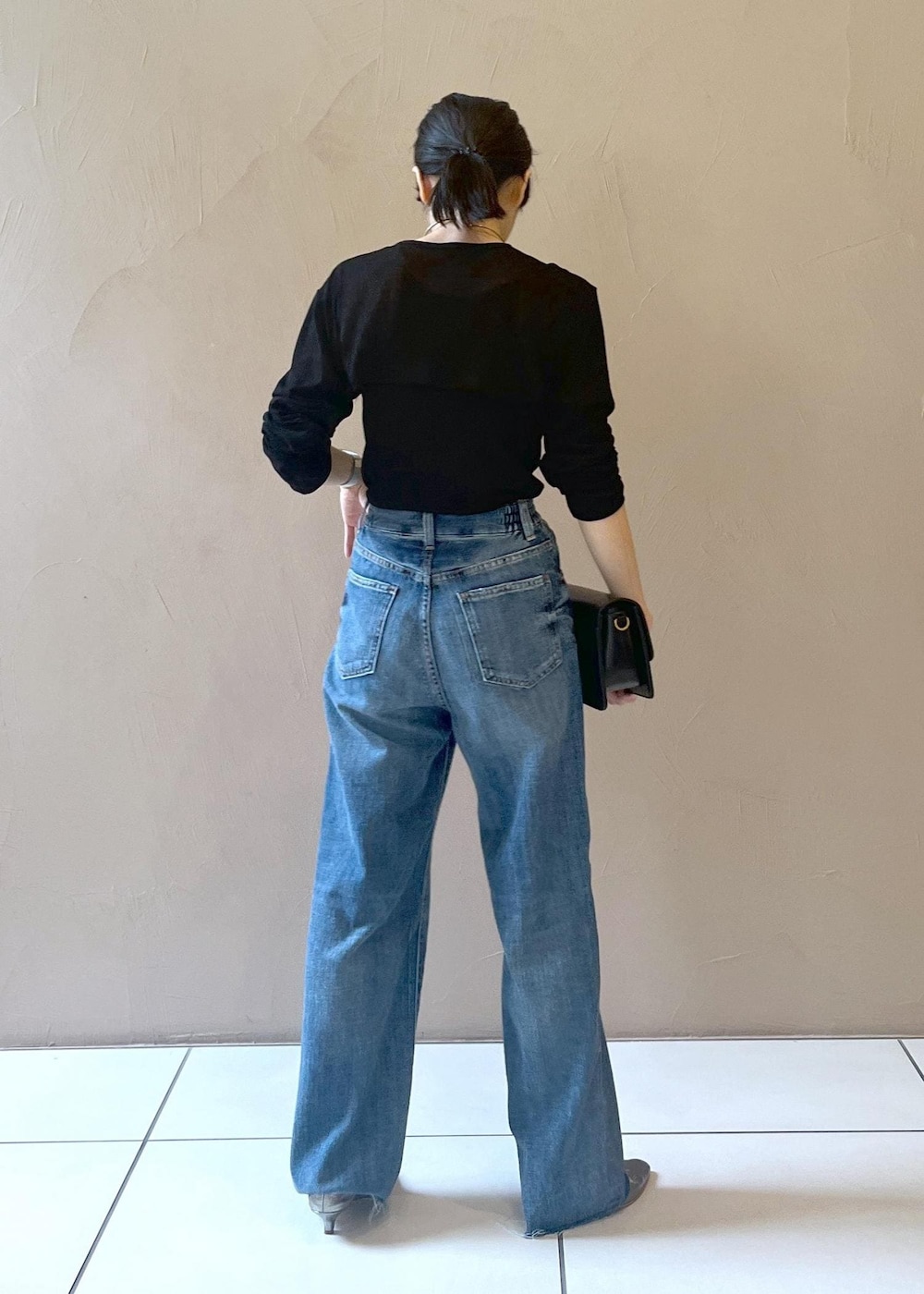 ブルー系のデニムパンツ、ブラック系のショルダーバッグ、ブラック系のカーディガン/ボレロを着用したレディースの夏コーディネートの3枚目の写真