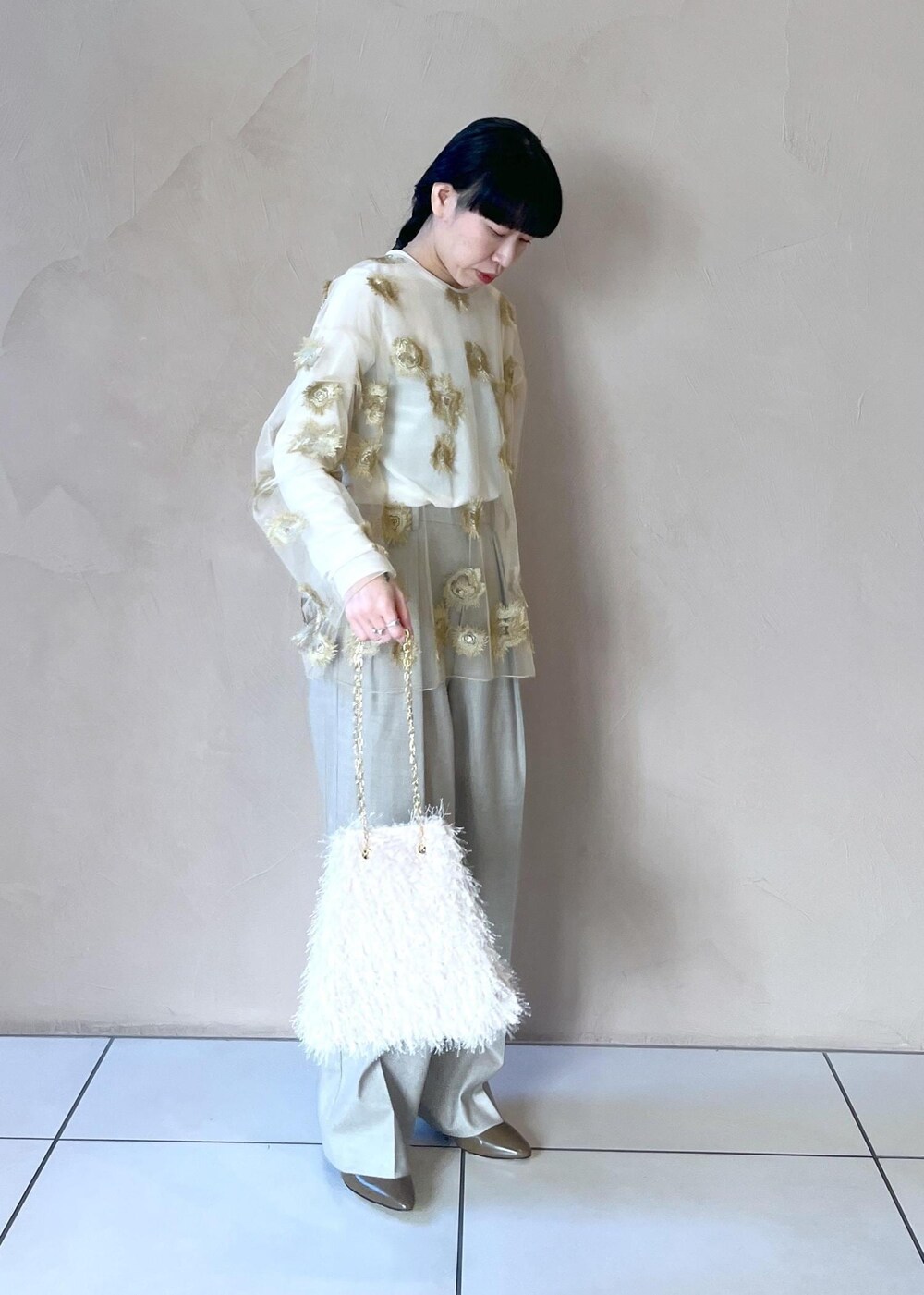 ゴールド系のTシャツ/カットソー、ホワイト系のTシャツ/カットソー、ベージュ系のスラックスを着用したレディースの冬コーディネートの6枚目の写真