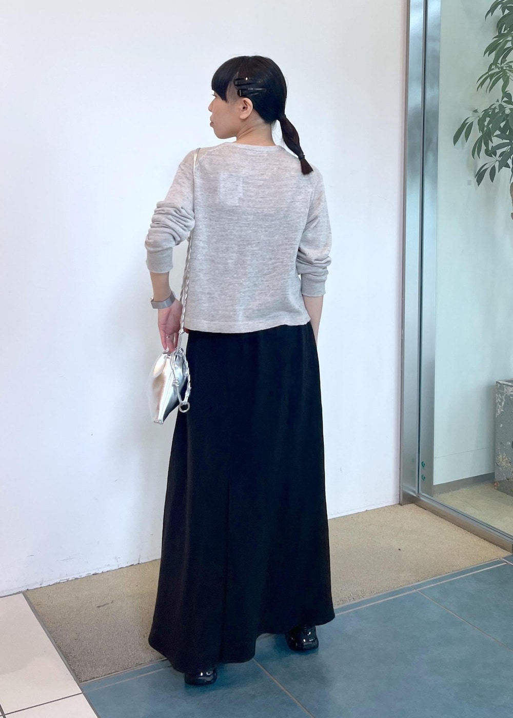 グレー系のカーディガン/ボレロ、ブラック系のスカート、シルバー系のショルダーバッグを着用したレディースの春コーディネートの4枚目の写真