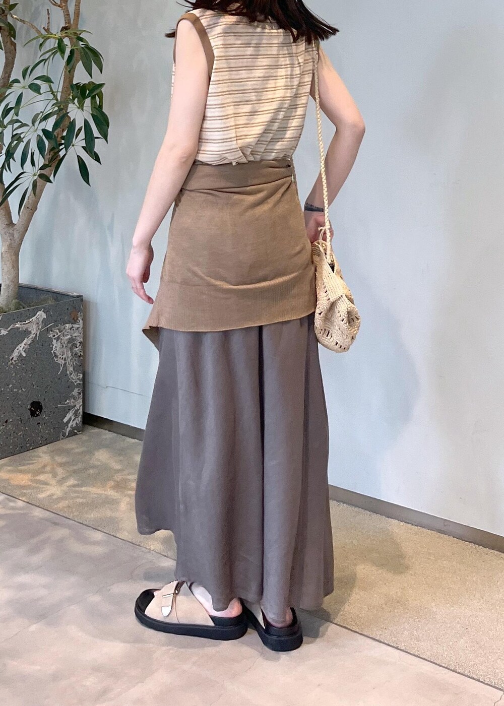 ベージュ系のサンダル、グレー系のスカート、ゴールド系のカーディガン/ボレロを着用したレディースの春コーディネートの4枚目の写真