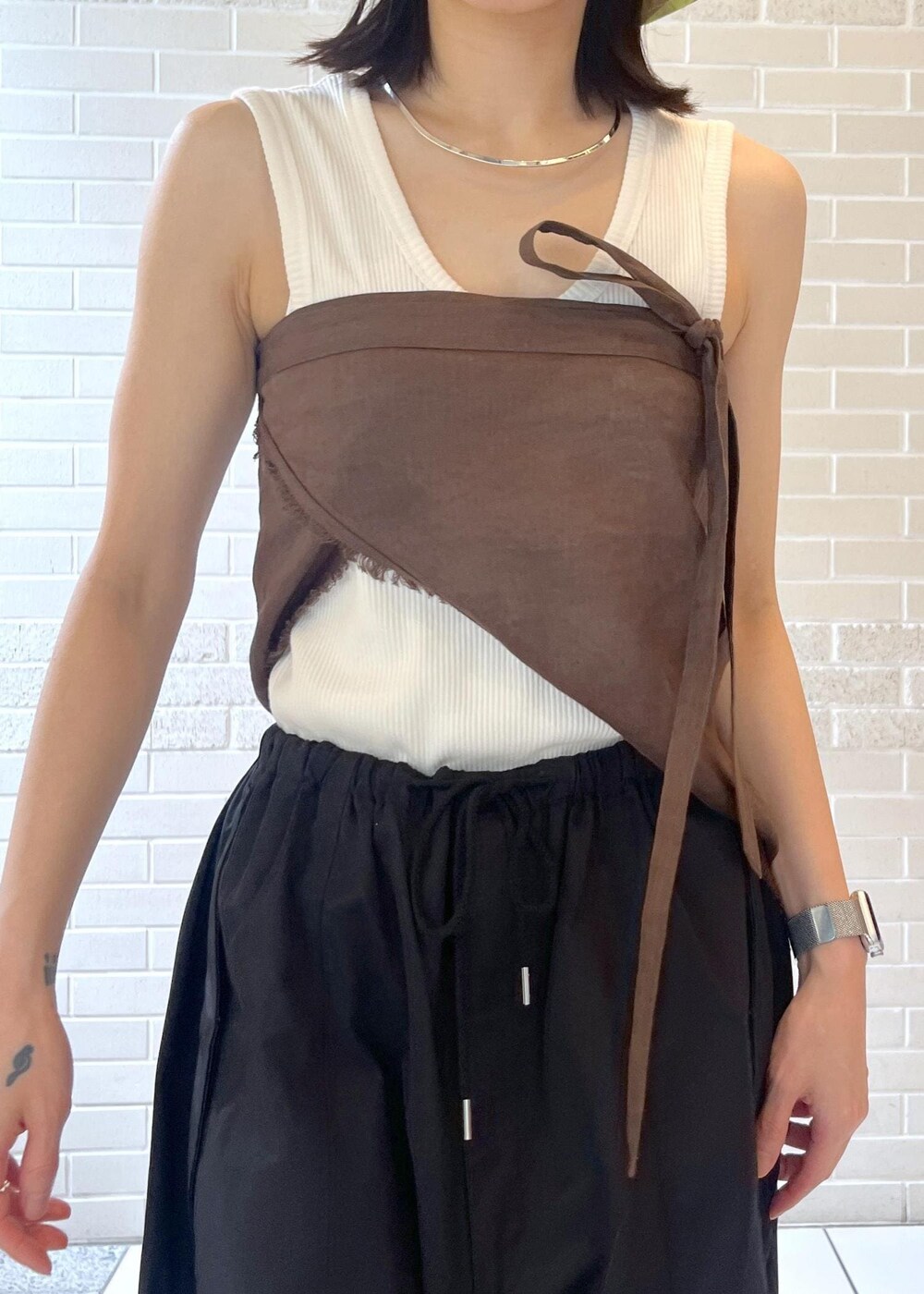 ホワイト系のタンクトップ、ブラック系のサンダル、ブラック系のカーゴパンツを着用したレディースの夏コーディネートの4枚目の写真