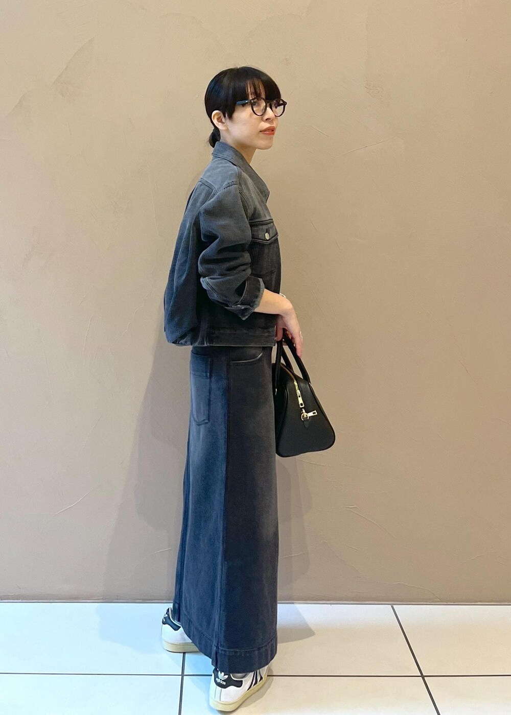 ブラック系のボストンバッグ、グレー系のデニムスカート、グレー系のデニムジャケットを着用したレディースの秋コーディネートの2枚目の写真