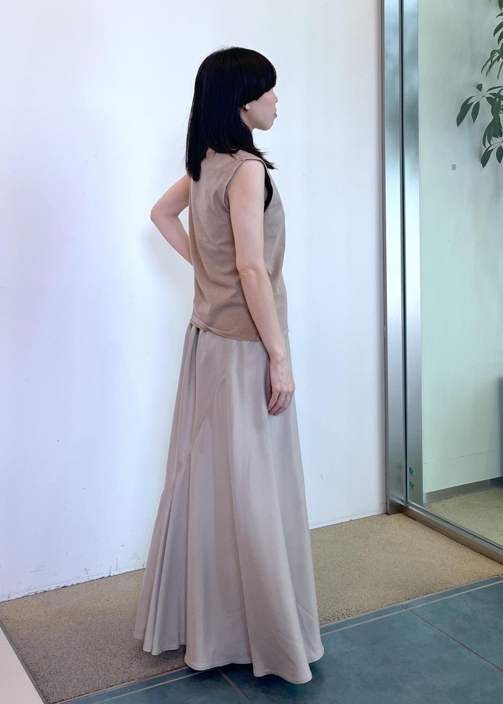 ベージュ系のスカート、ベージュ系のタンクトップ、グリーン系のストール/ショールを着用したレディースの夏コーディネートの4枚目の写真