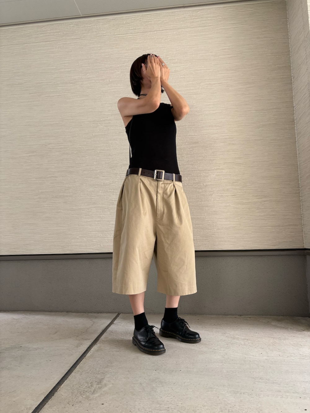 ベージュ系のチノパンツ、ブラック系のドレスシューズ、ブラック系のタンクトップを着用したレディースの夏コーディネートの2枚目の写真