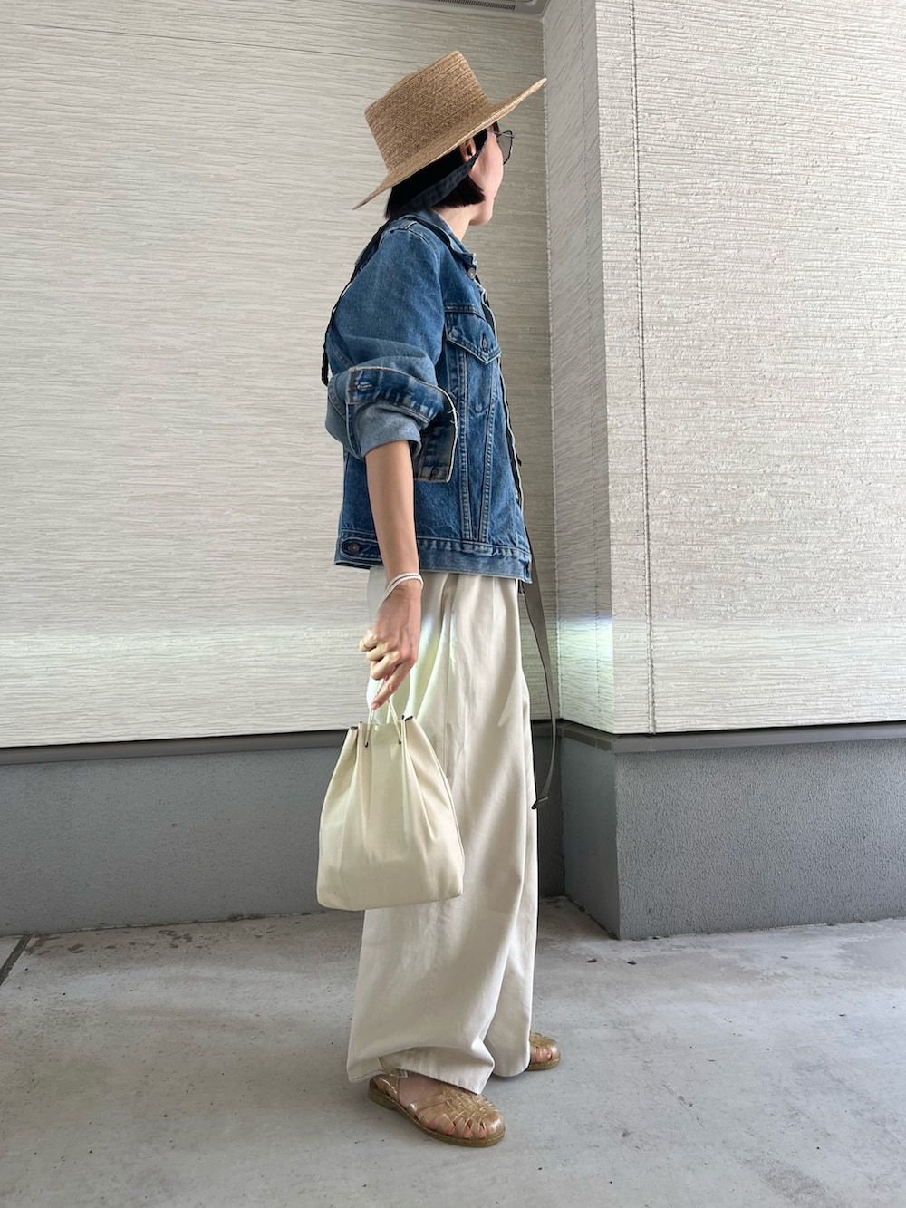 ホワイト系のハンドバッグ、ベージュ系のチノパンツ、ベージュ系のタンクトップを着用したレディースの春コーディネートの2枚目の写真