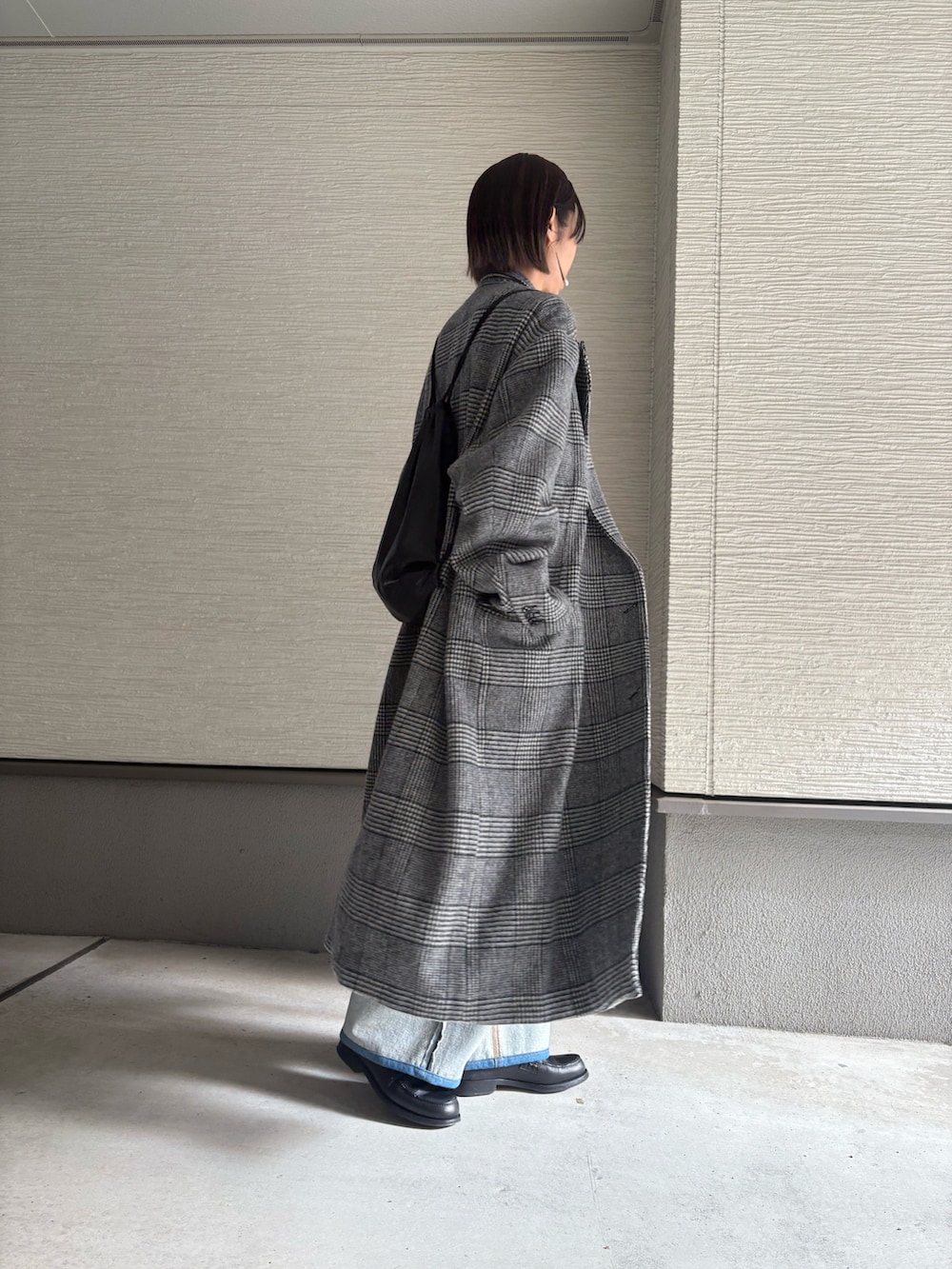 ブラック系のローファー、ブルー系のデニムパンツ、グレー系のジャケット/アウターを着用したレディースの冬コーディネートの2枚目の写真