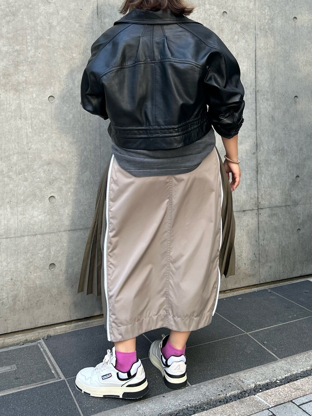 ベージュ系のスカート、ブラック系のTシャツ/カットソー、ブラック系のその他アウターを着用したレディースの秋コーディネートの5枚目の写真