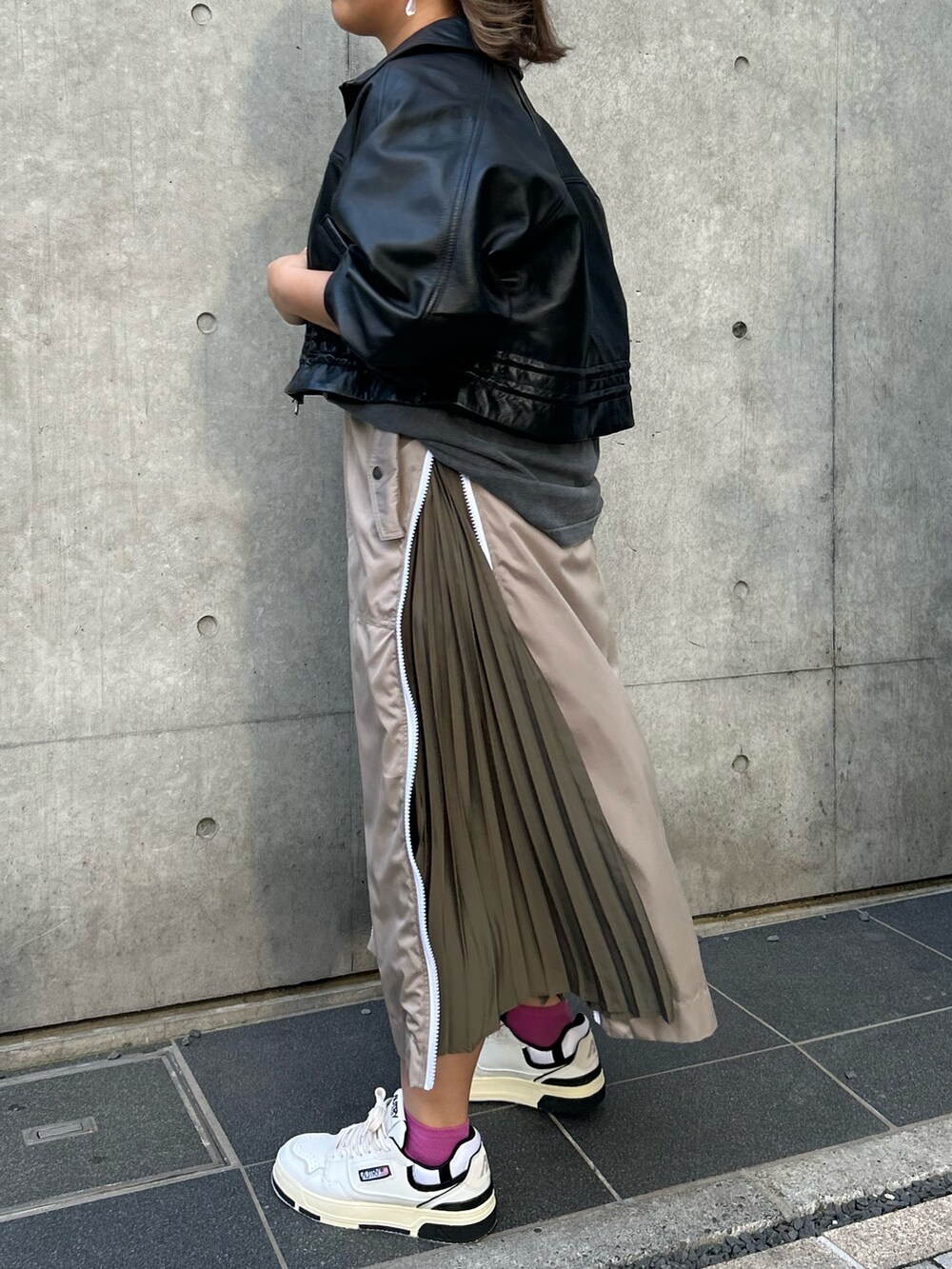ベージュ系のスカート、ブラック系のTシャツ/カットソー、ブラック系のその他アウターを着用したレディースの秋コーディネートの7枚目の写真