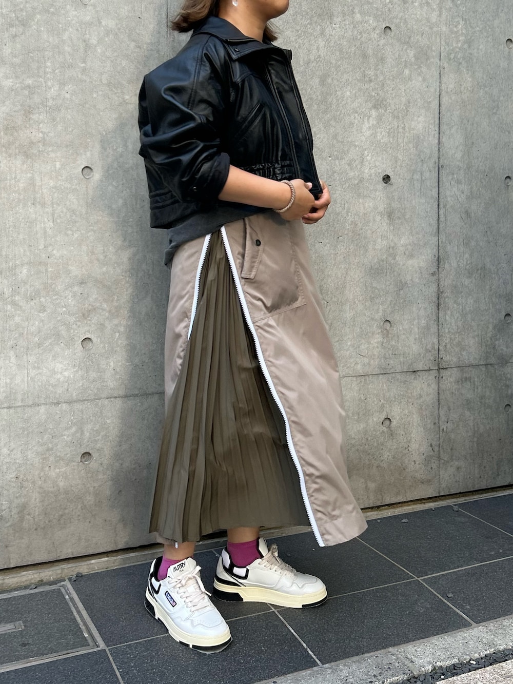 ベージュ系のスカート、ブラック系のTシャツ/カットソー、ブラック系のその他アウターを着用したレディースの秋コーディネートの4枚目の写真