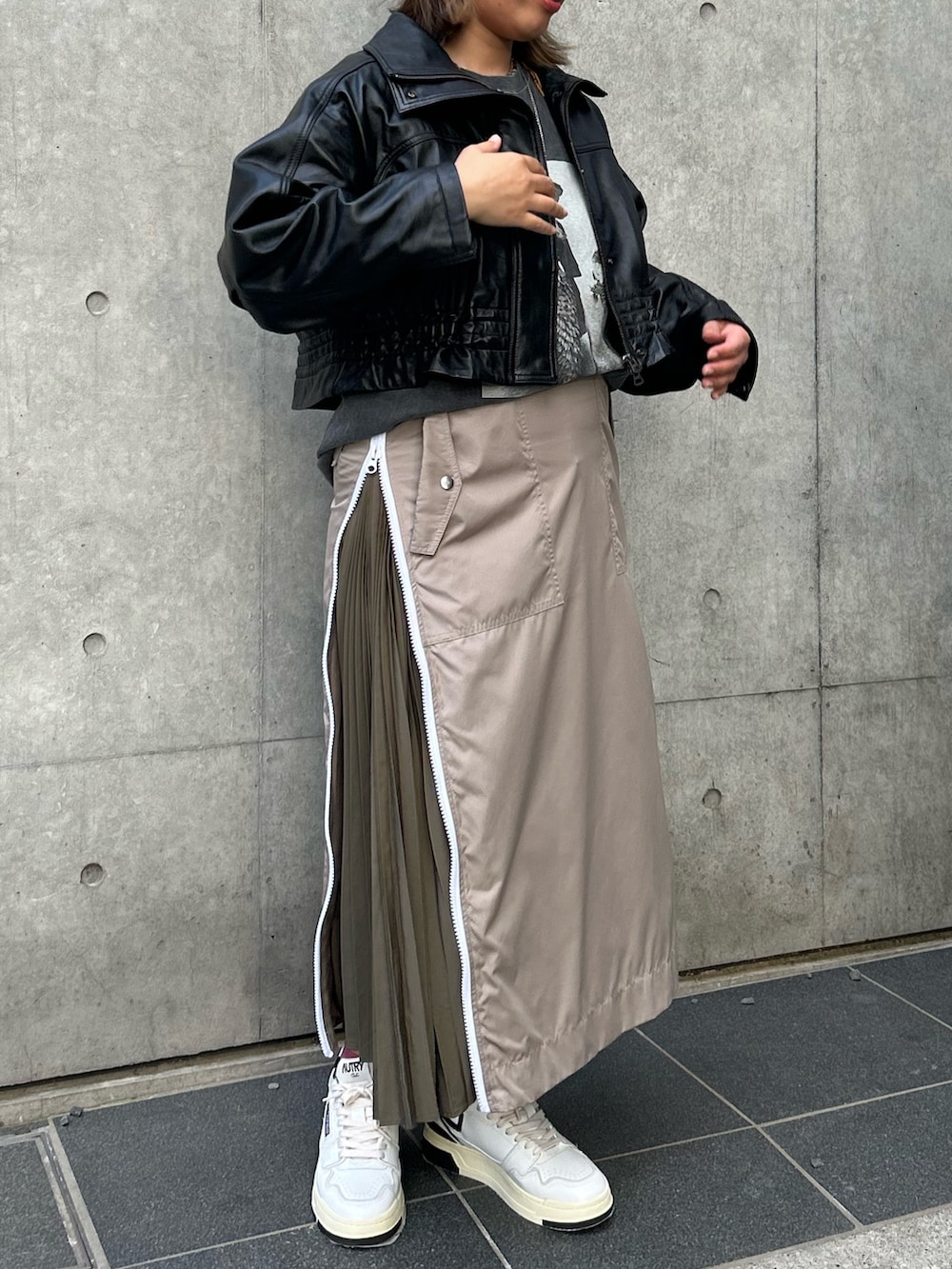 ベージュ系のスカート、ブラック系のTシャツ/カットソー、ブラック系のその他アウターを着用したレディースの秋コーディネートの3枚目の写真