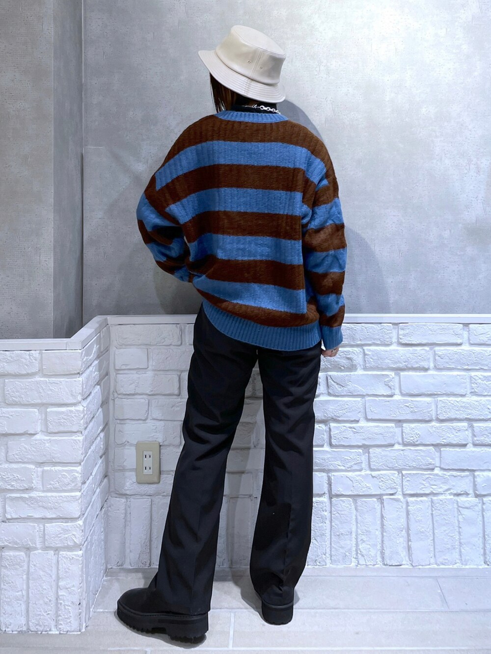 ブラック系のTシャツ/カットソー、ブラック系のニット/セーター、ブラック系のスラックスを着用したレディースの冬コーディネートの2枚目の写真