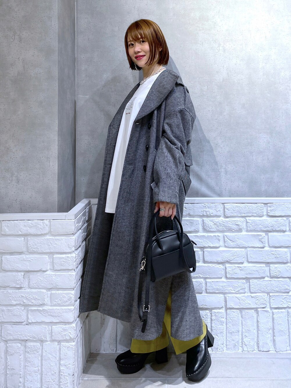 ホワイト系のTシャツ/カットソー、イエロー系のパンツ、ブラック系のその他アウターを着用したレディースの冬コーディネートの3枚目の写真