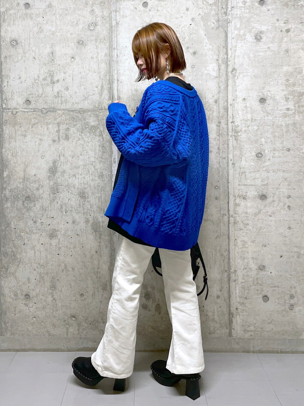 ブラック系のスウェット、ブルー系のニット/セーター、ブラック系のボストンバッグを着用したレディースの冬コーディネートの2枚目の写真