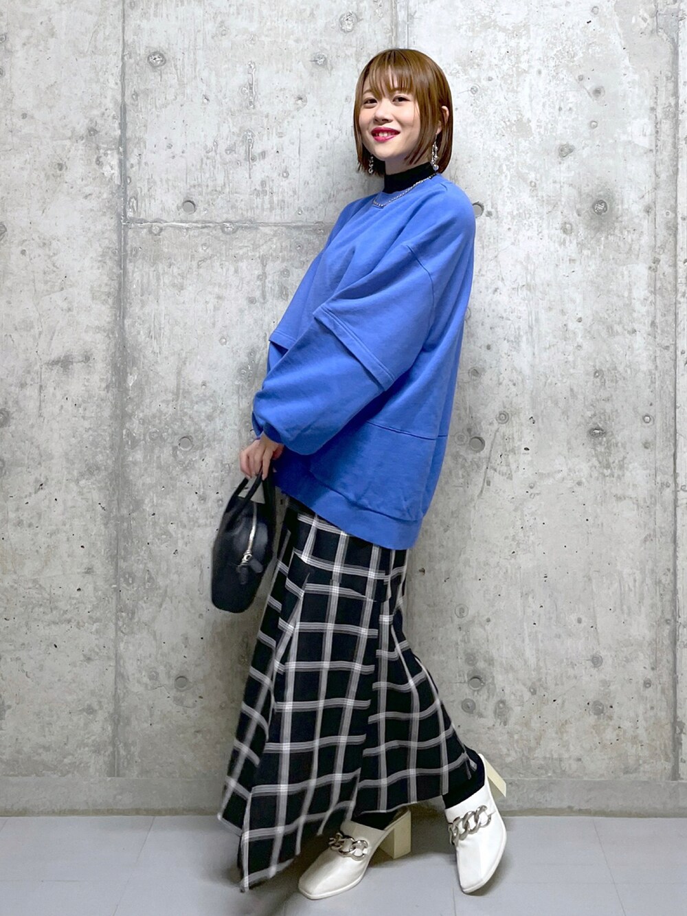 ブルー系のスウェット、ホワイト系のデニムパンツ、ブラック系のブーツを着用したレディースの冬コーディネートの4枚目の写真