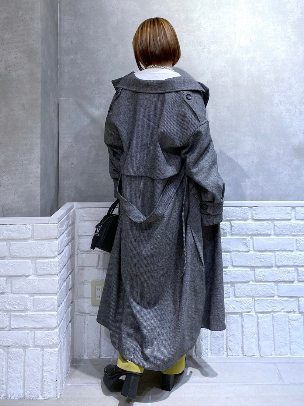 ホワイト系のTシャツ/カットソー、イエロー系のパンツ、ブラック系のその他アウターを着用したレディースの冬コーディネートの4枚目の写真