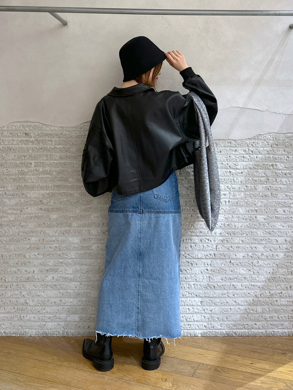 グレー系のタンクトップ、ブラック系のブルゾン、シルバー系のトートバッグを着用したレディースの冬コーディネートの2枚目の写真