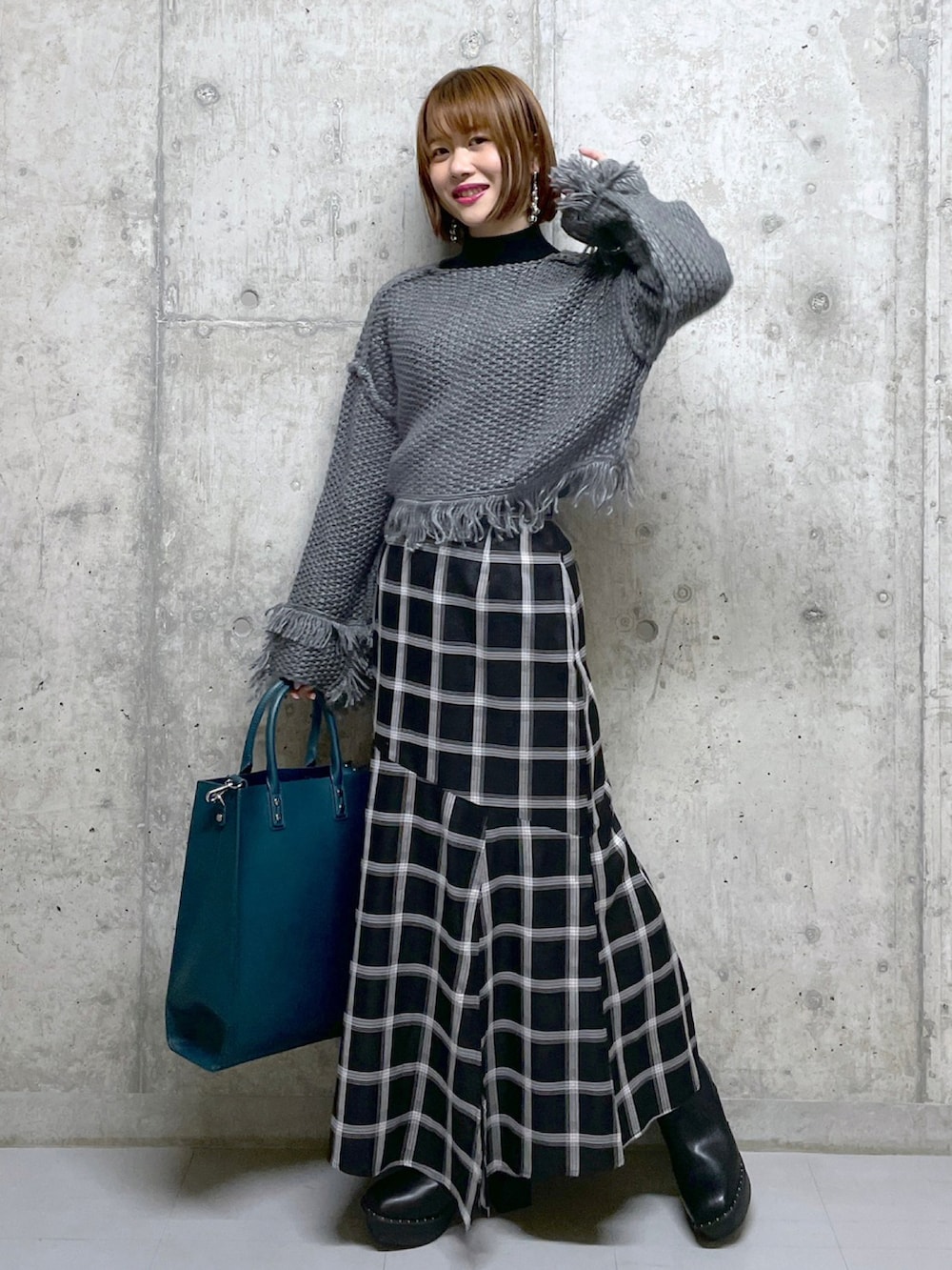 ブラック系のワンピース、ホワイト系のTシャツ/カットソー、グリーン系のトートバッグを着用したレディースの冬コーディネートの4枚目の写真