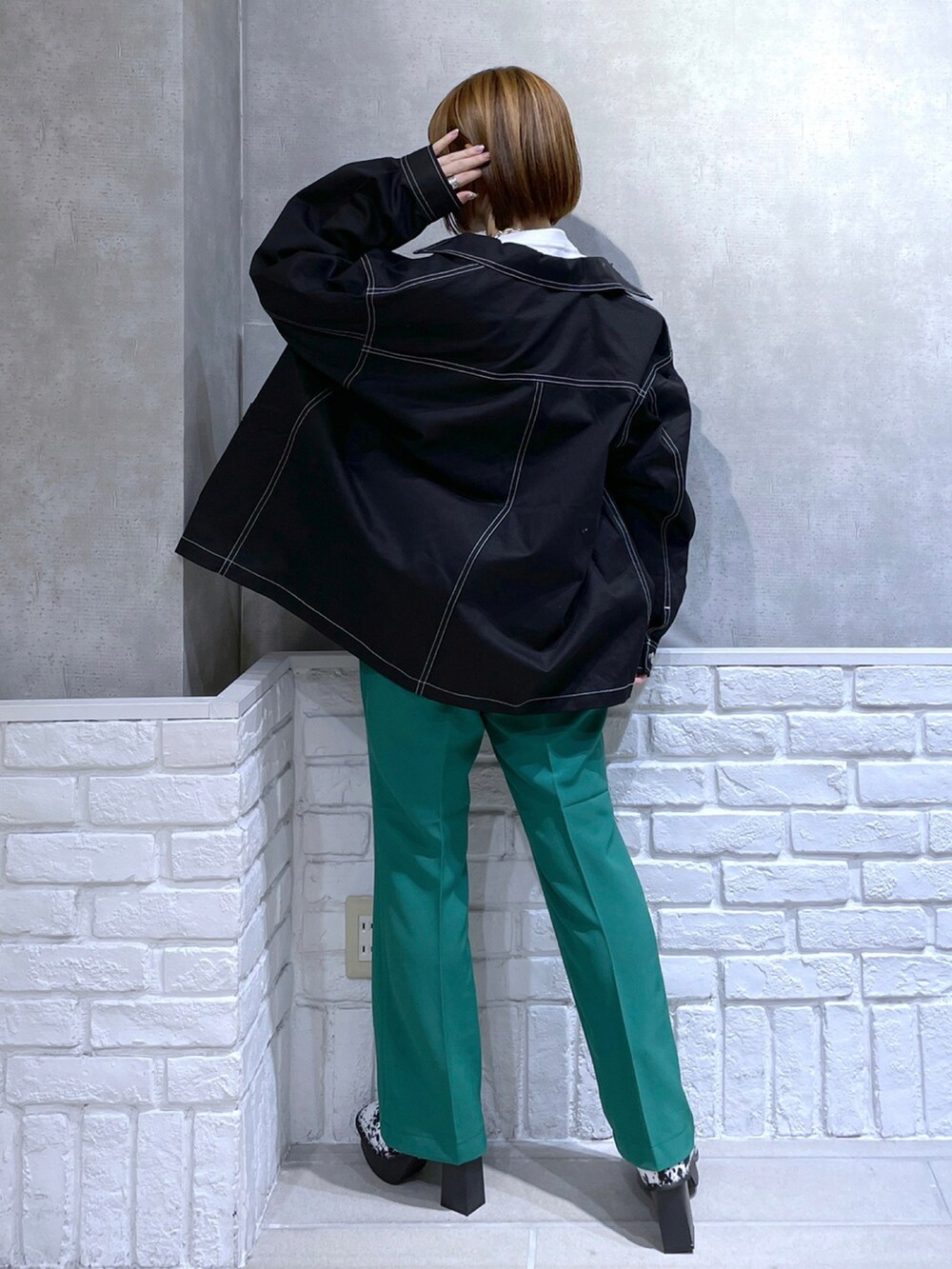 ホワイト系のTシャツ/カットソー、ブラック系のカバーオール、グリーン系のパンツを着用したレディースの冬コーディネートの2枚目の写真