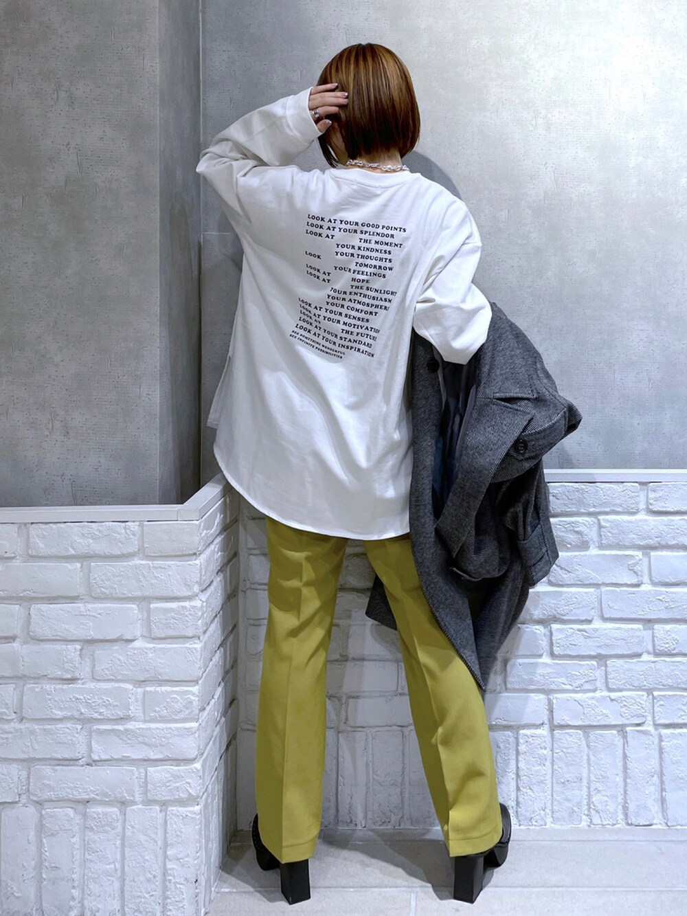 ホワイト系のTシャツ/カットソー、イエロー系のパンツ、ブラック系のその他アウターを着用したレディースの冬コーディネートの2枚目の写真