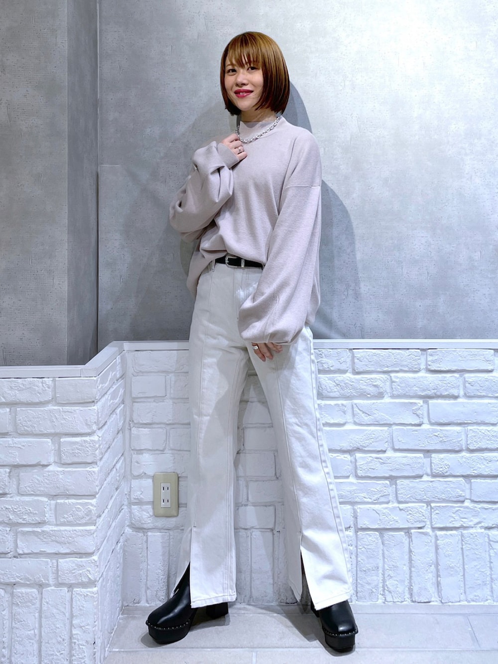 ベージュ系のニット/セーター、ブラック系のその他アウター、ホワイト系のデニムパンツを着用したレディースの冬コーディネートの3枚目の写真