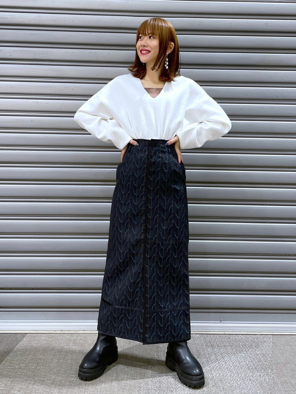 ホワイト系のニット/セーター、ブラウン系のブルゾン、ブラック系のスカートを着用したレディースの冬コーディネートの2枚目の写真