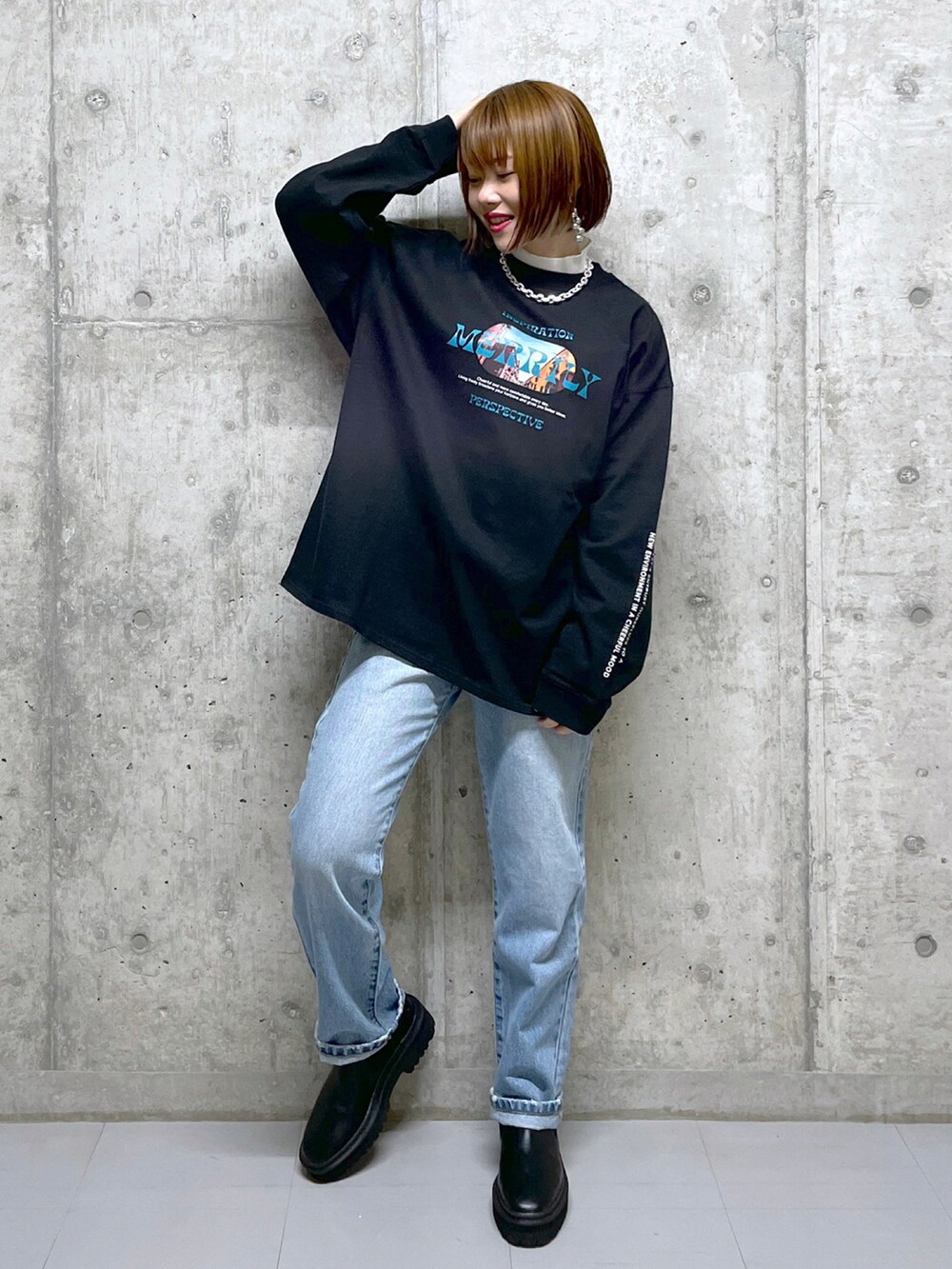 ブラック系のTシャツ/カットソー、イエロー系のニット/セーター、ブルー系のデニムパンツを着用したレディースの冬コーディネートの3枚目の写真