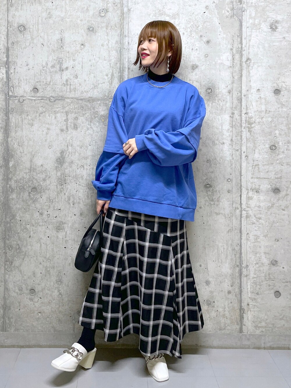 ブルー系のスウェット、ホワイト系のデニムパンツ、ブラック系のブーツを着用したレディースの冬コーディネートの3枚目の写真