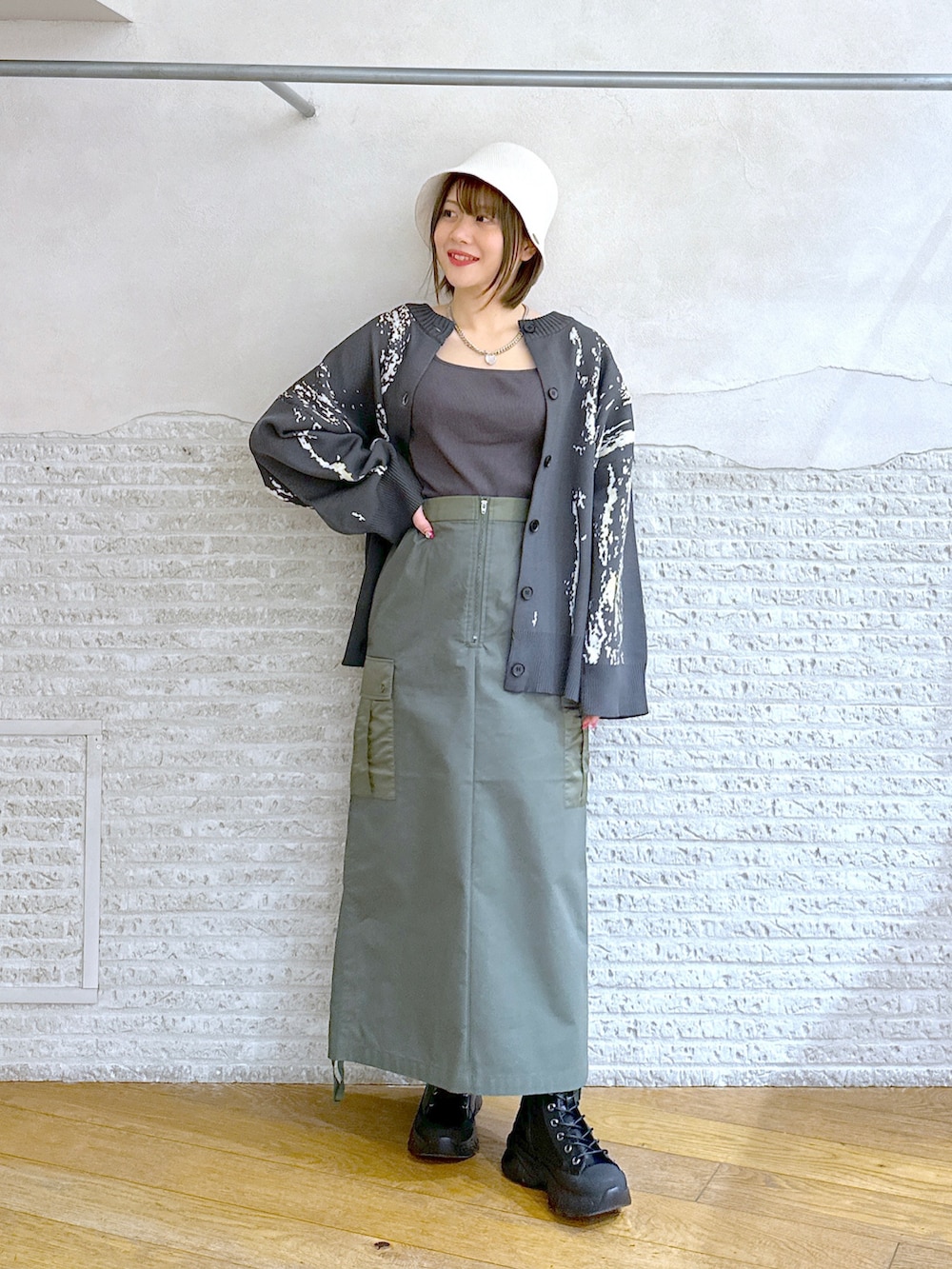 グレー系のカーディガン/ボレロ、グリーン系のスカートを着用したレディースの春コーディネートの2枚目の写真