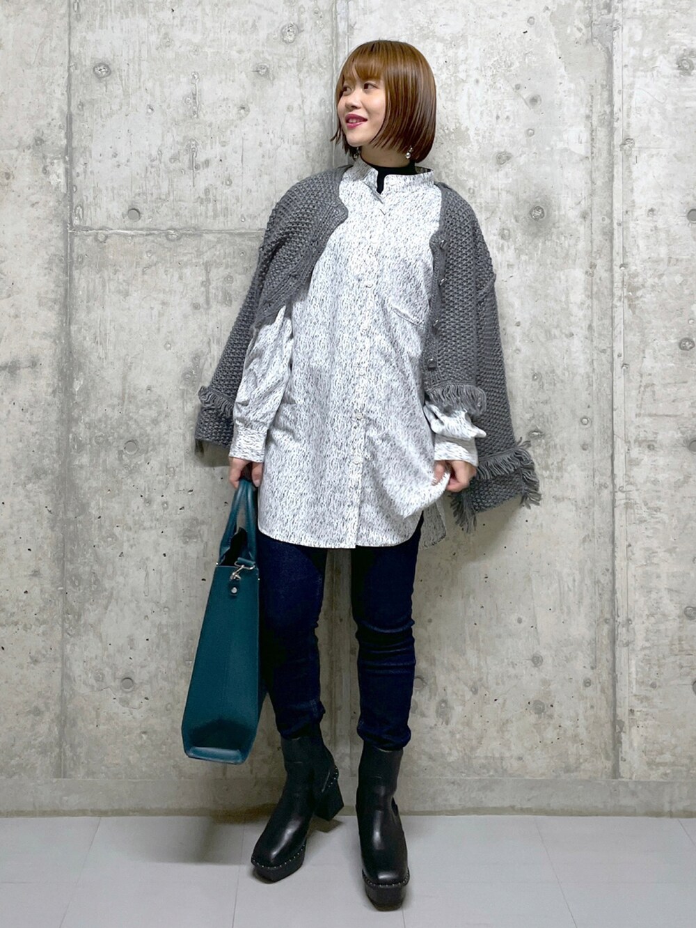 ブラック系のワンピース、ホワイト系のTシャツ/カットソー、グリーン系のトートバッグを着用したレディースの冬コーディネートの2枚目の写真