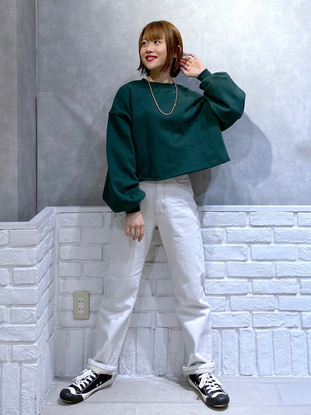 ブラック系のブルゾン、ベージュ系のデニムパンツ、ブラック系のスニーカーを着用したレディースの冬コーディネートの2枚目の写真