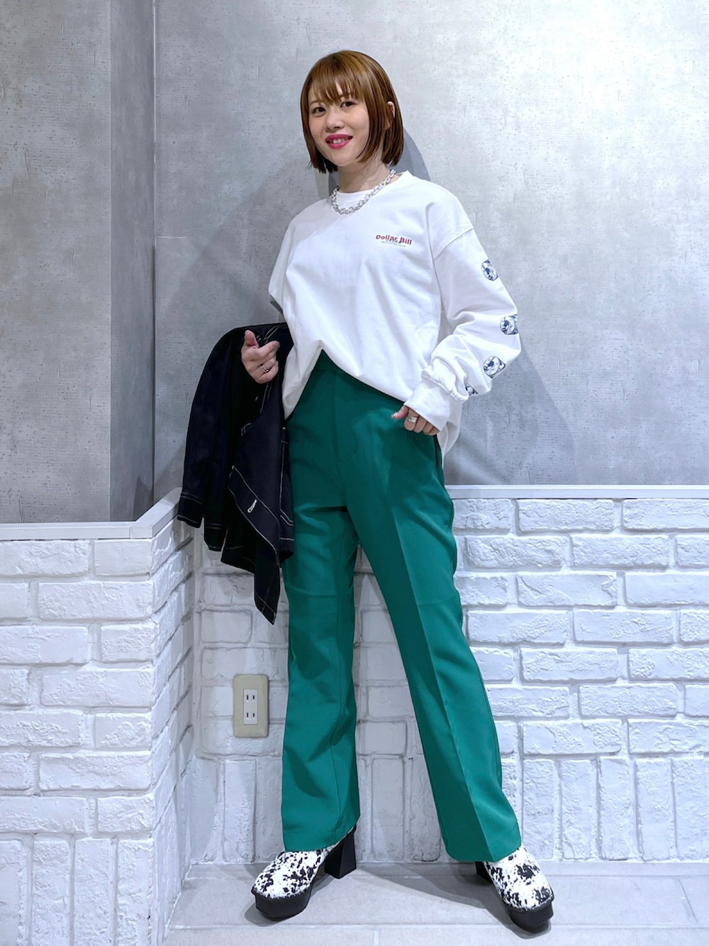 ホワイト系のTシャツ/カットソー、ブラック系のカバーオール、グリーン系のパンツを着用したレディースの冬コーディネートの4枚目の写真