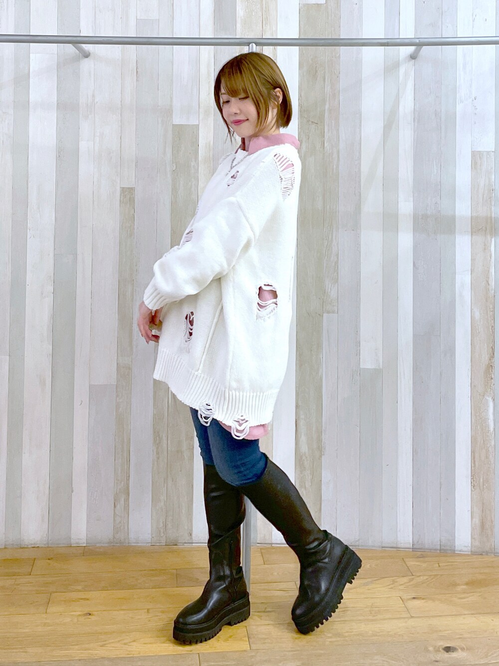 ブラック系のブーツ、ブルー系のデニムパンツ、ホワイト系のニット/セーターを着用したレディースの冬コーディネートの2枚目の写真