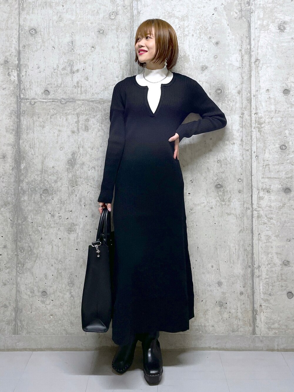 ブラウン系のブルゾン、ブラック系のワンピース、ブラック系のトートバッグを着用したレディースの冬コーディネートの3枚目の写真