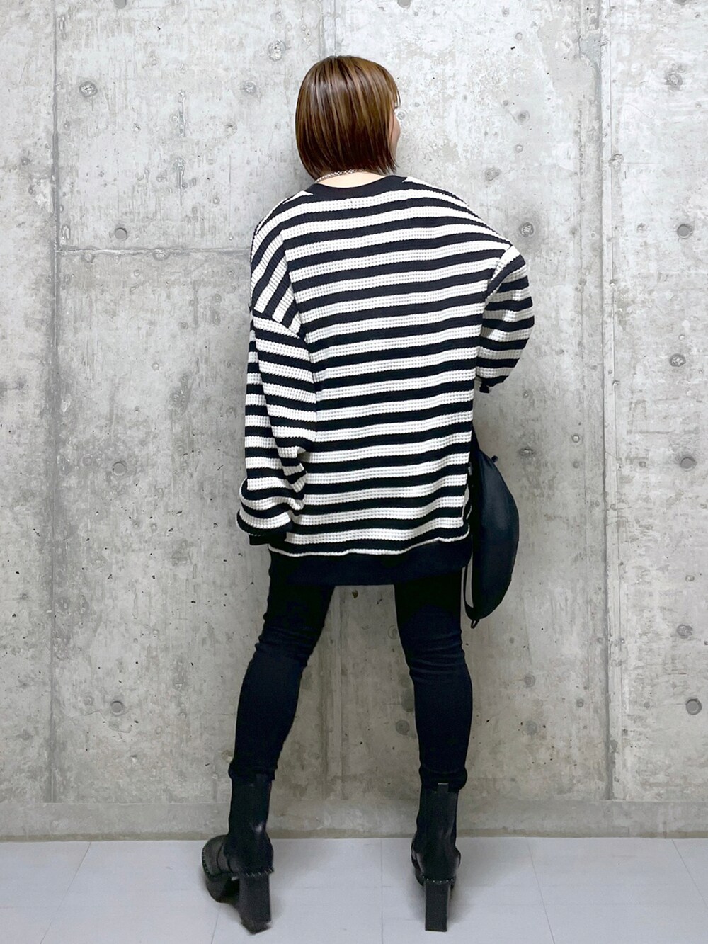 ブラック系のカーディガン/ボレロ、ブラック系のデニムパンツ、ブラック系のブーツを着用したレディースの冬コーディネートの2枚目の写真