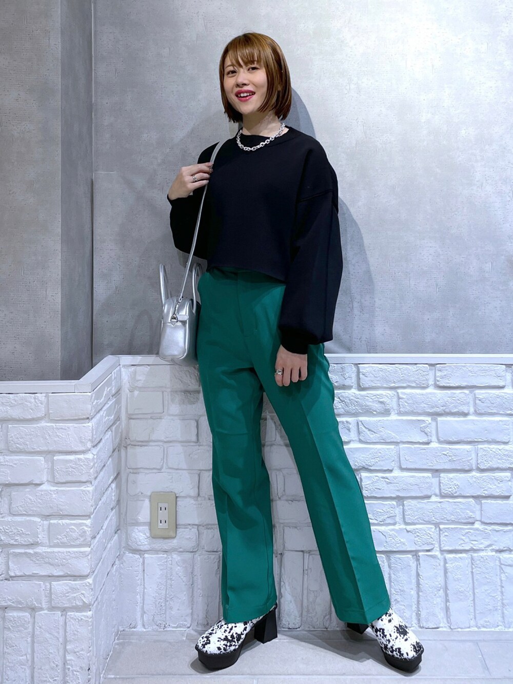 ブラック系のニット/セーター、ブラック系のトートバッグ、レッド系のパンツを着用したレディースの冬コーディネートの3枚目の写真