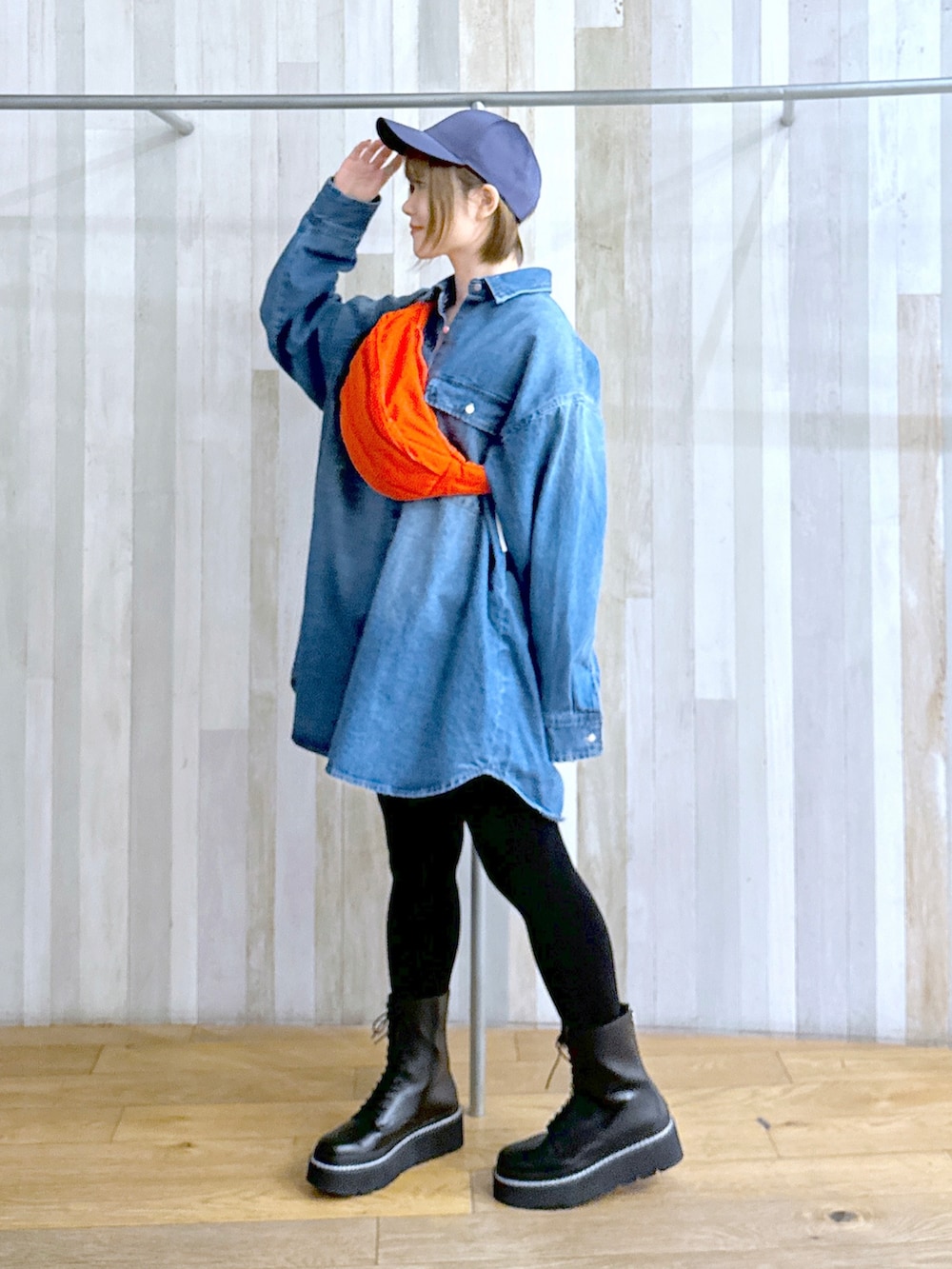 ブラック系のブーツ、オレンジ系のショルダーバッグ、ブルー系のシャツ/ブラウスを着用したレディースの冬コーディネートの2枚目の写真