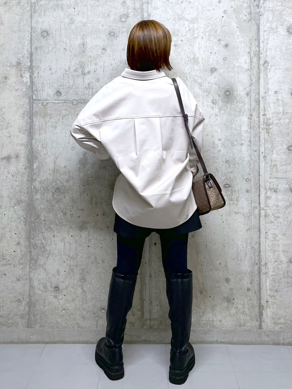 ブラック系のその他パンツ、ブラウン系のショルダーバッグ、ベージュ系のシャツ/ブラウスを着用したレディースの冬コーディネートの2枚目の写真