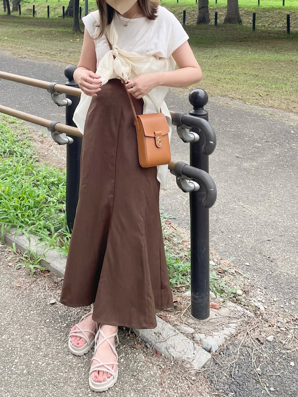 ホワイト系のキャミソール、ホワイト系のシャツ/ブラウス、ブラウン系のスカートを着用したレディースの夏コーディネートの3枚目の写真