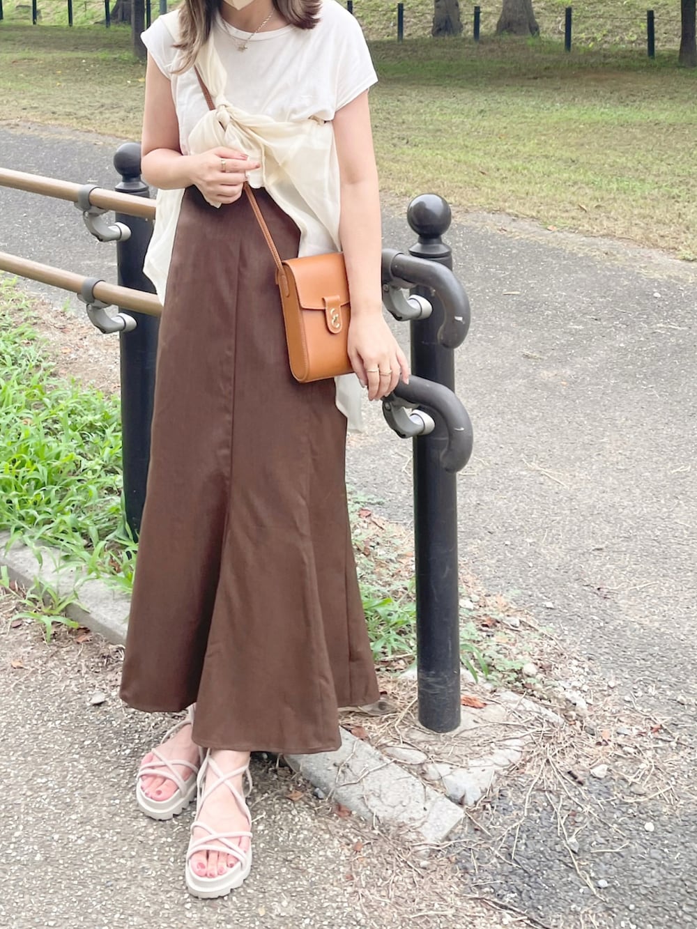ホワイト系のキャミソール、ホワイト系のシャツ/ブラウス、ブラウン系のスカートを着用したレディースの夏コーディネートの2枚目の写真