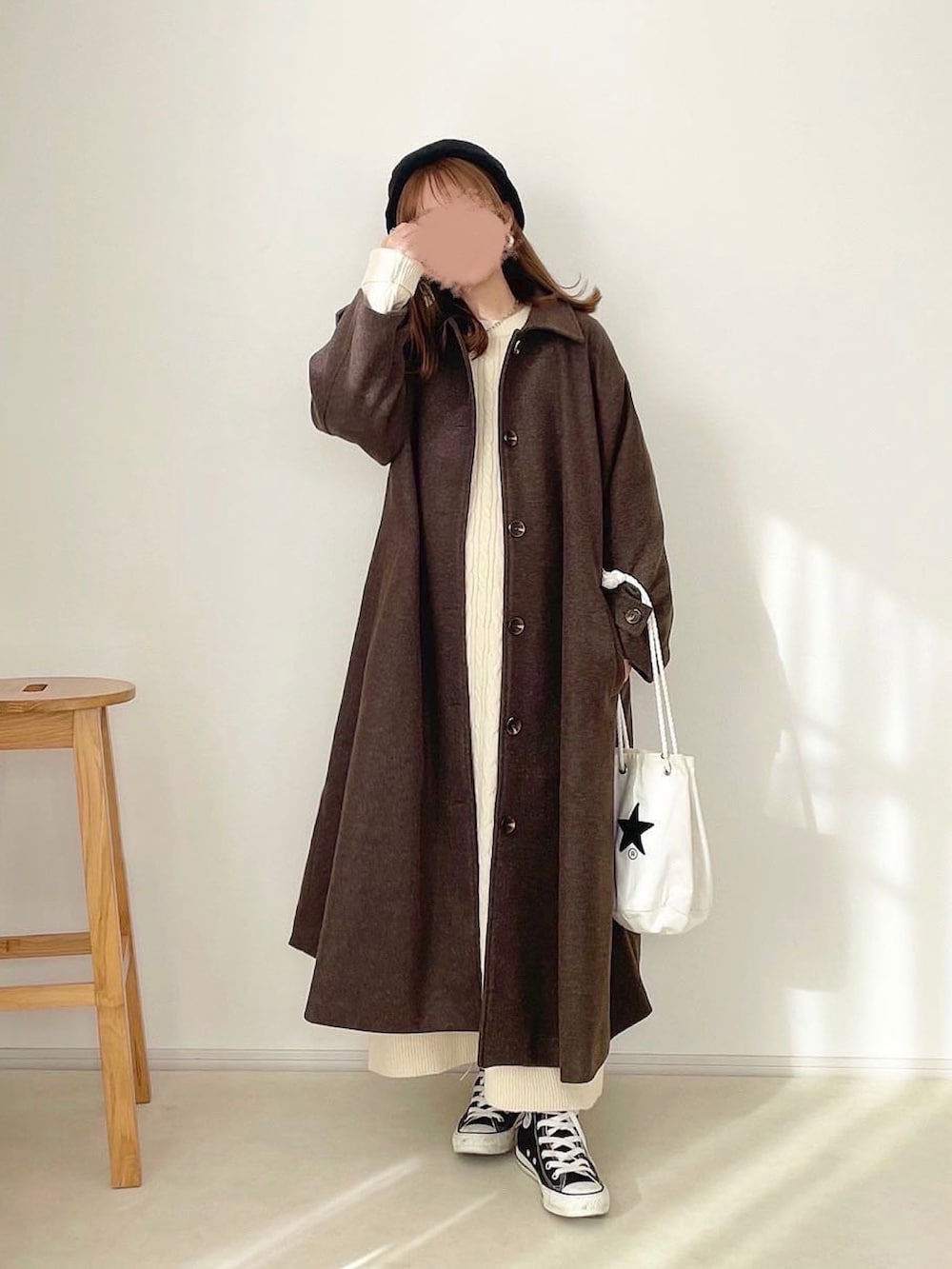 ベージュ系のワンピース、ベージュ系のステンカラーコート、ホワイト系のショルダーバッグを着用したレディースの冬コーディネートの2枚目の写真