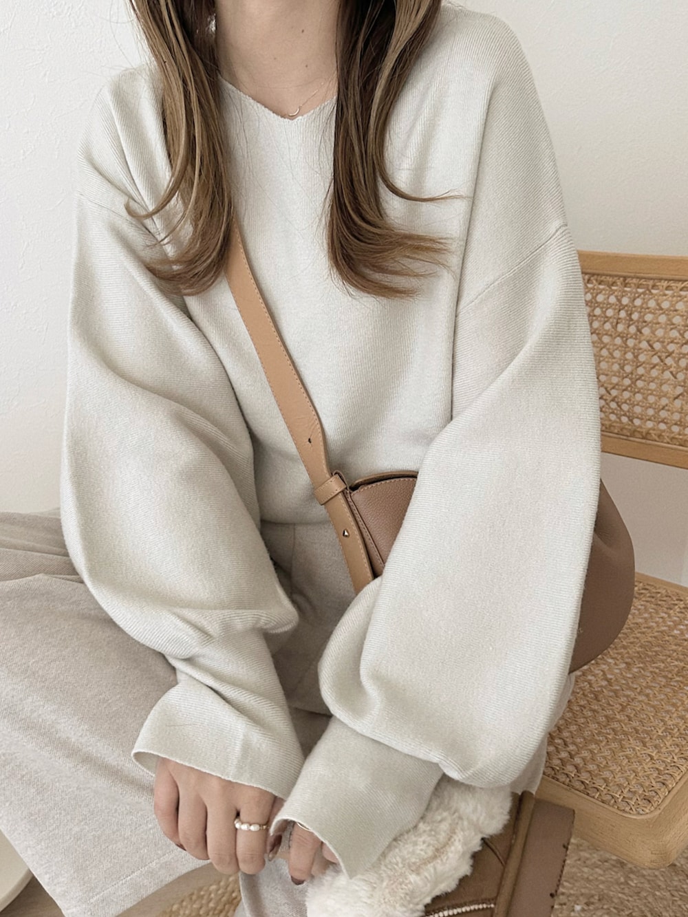 ホワイト系のニット/セーター、ホワイト系のパンツ、ブラウン系のシューズを着用したレディースの秋コーディネートの2枚目の写真