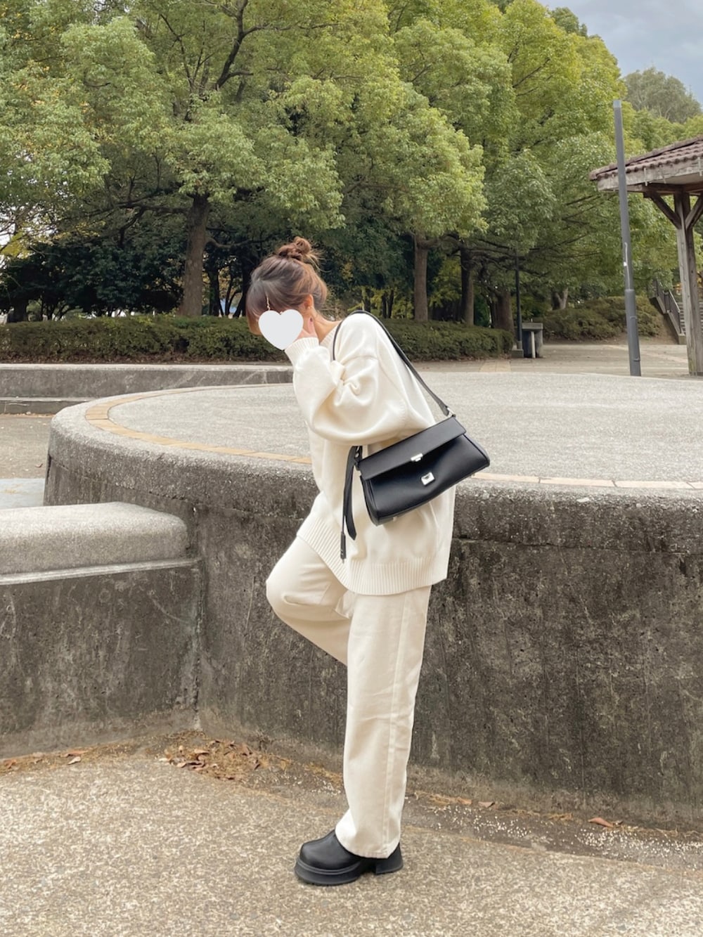 ブラック系のブルゾン、ホワイト系のニット/セーター、ブラック系のショルダーバッグを着用したレディースの秋コーディネートの2枚目の写真