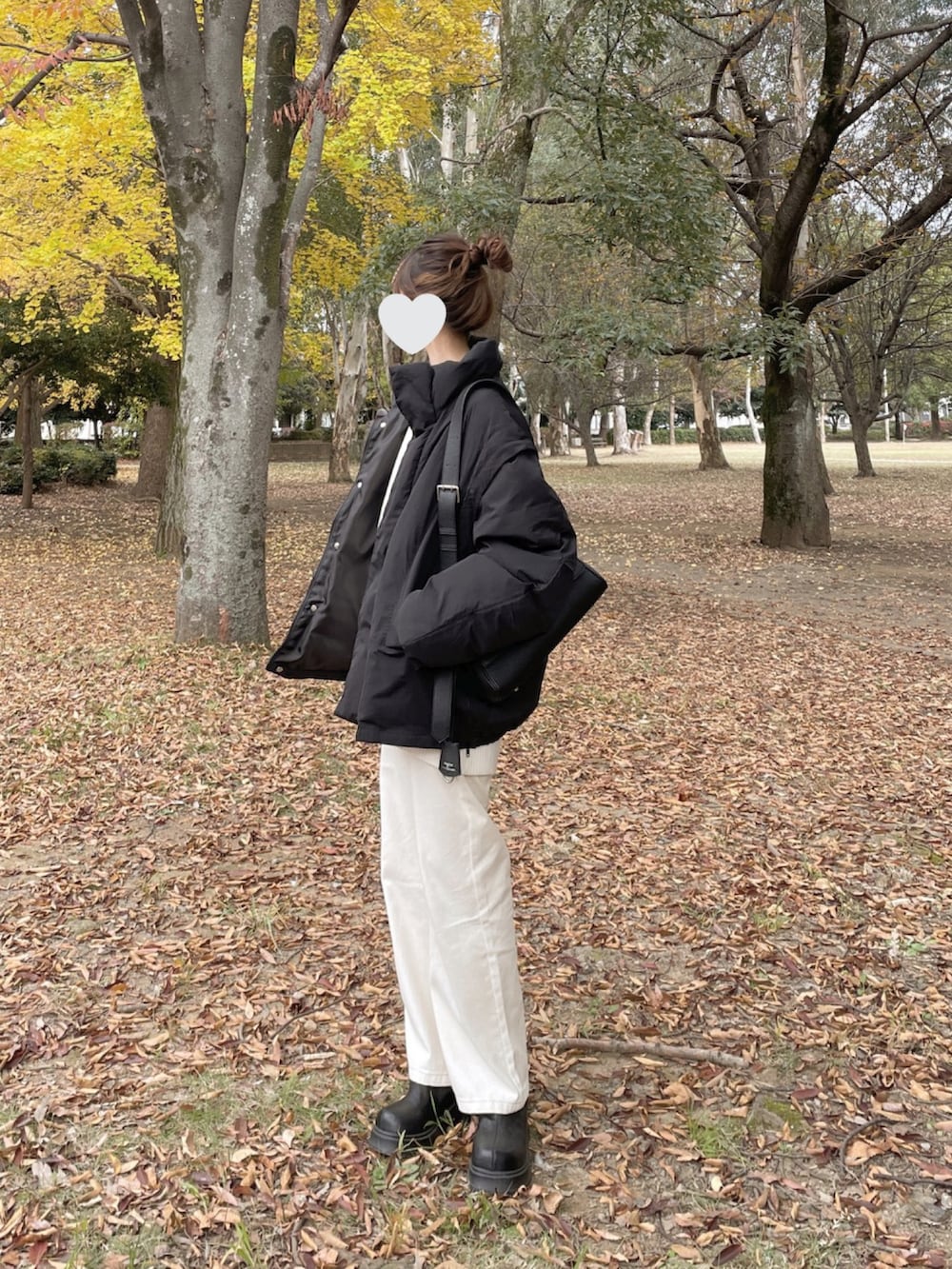 ブラック系のブルゾン、ホワイト系のニット/セーター、ブラック系のショルダーバッグを着用したレディースの秋コーディネートの3枚目の写真