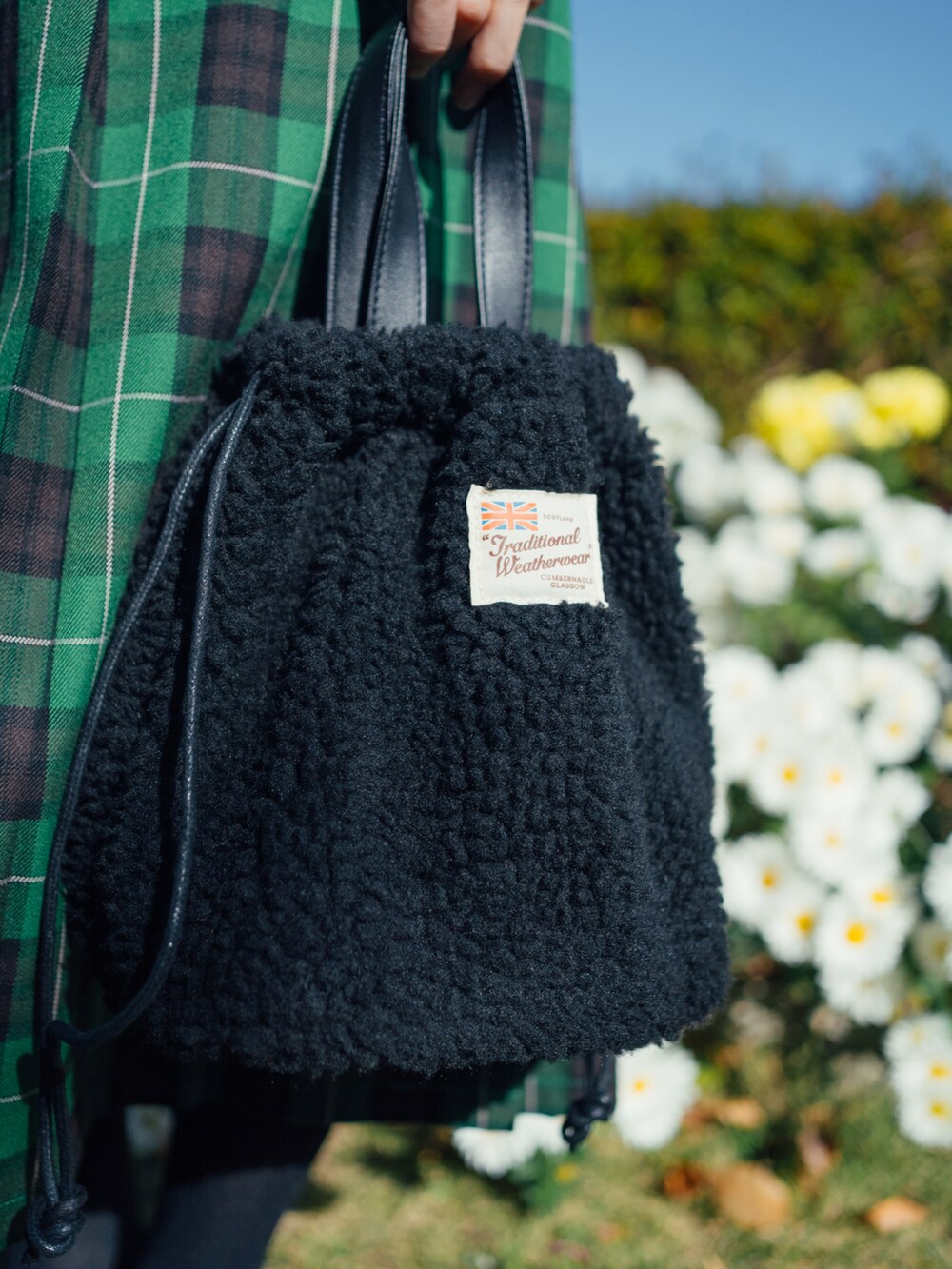 ホワイト系のノーカラージャケット、グリーン系のスカート、ブラック系のバレエシューズを着用したレディースの冬コーディネートの2枚目の写真