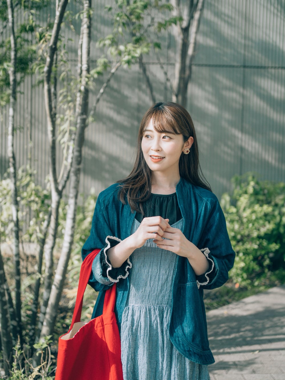 ブルー系のワンピース、ブラック系のシャツ/ブラウス、レッド系のバッグを着用したレディースの春コーディネートの3枚目の写真