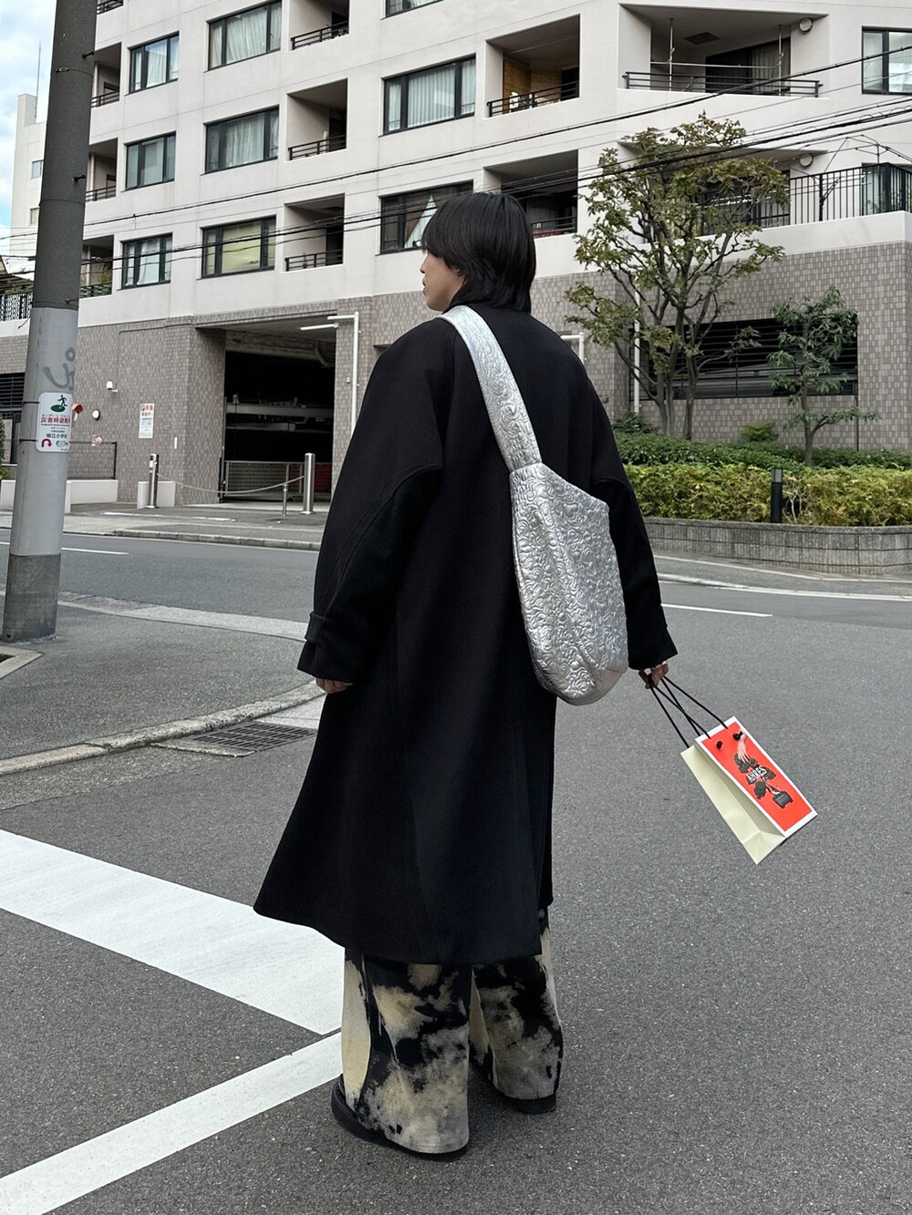 ブラック系のステンカラーコート、シルバー系のショルダーバッグ、その他のパンツを着用したメンズの秋コーディネートの3枚目の写真