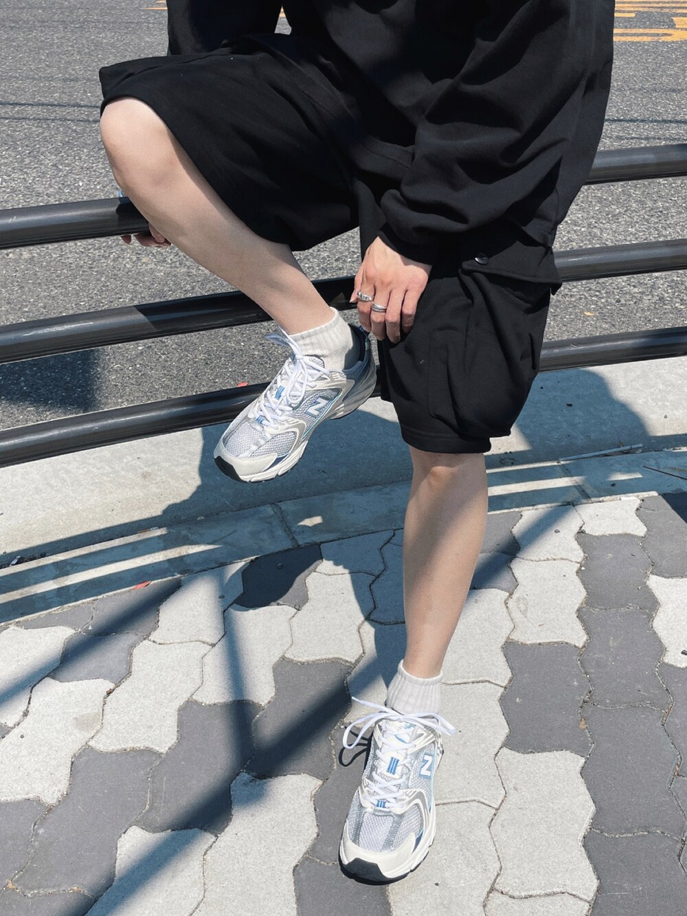 ブラック系のTシャツ/カットソー、ブラック系のパンツ、シルバー系のスニーカーを着用したメンズの夏コーディネートの2枚目の写真