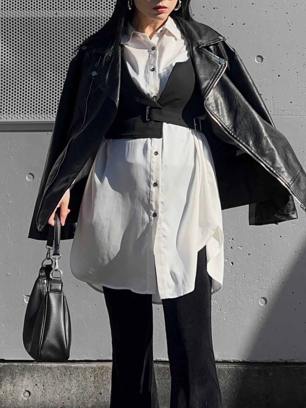 ホワイト系のシャツ/ブラウス、ブラック系のベスト、ブラック系のライダースジャケットを着用したレディースの冬コーディネートの2枚目の写真