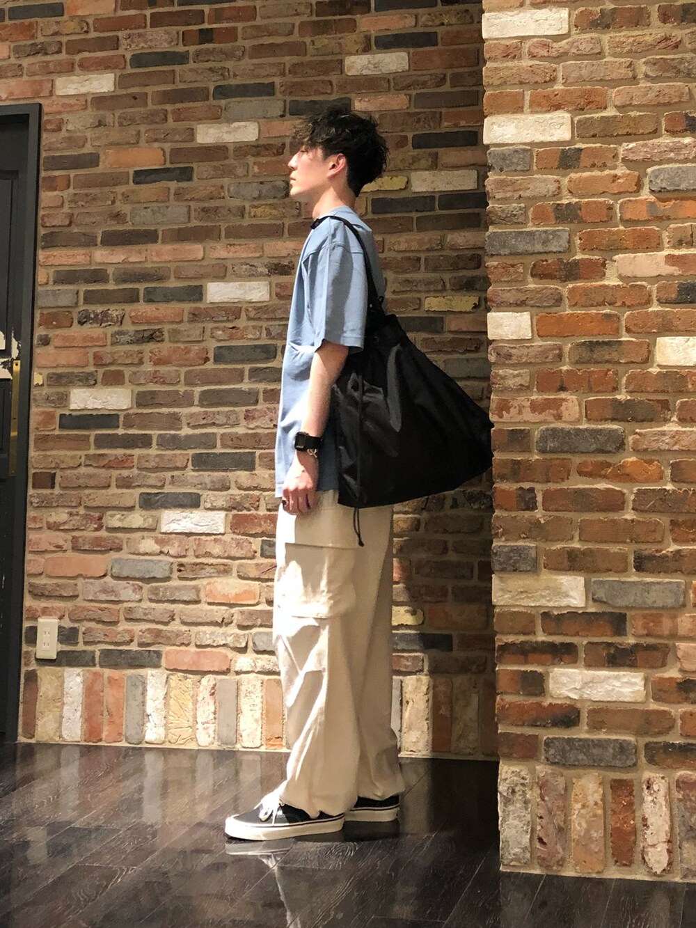 グレー系のTシャツ/カットソー、ベージュ系のカーゴパンツ、ブラック系のトートバッグを着用したメンズの春コーディネートの2枚目の写真